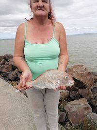 Man holding fish at beach