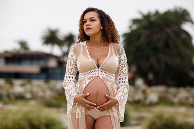 Young pregnant woman posing on beach