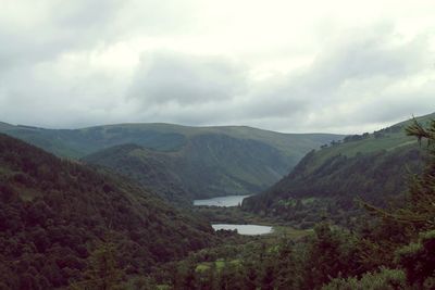 Scenic view of river and mountains against sky