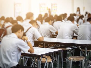 Students sitting on benches in classroom