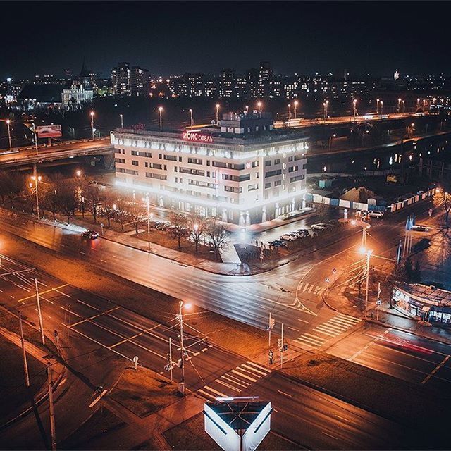 illuminated, night, building exterior, architecture, city, built structure, high angle view, transportation, cityscape, city life, street light, mode of transport, street, road, river, residential building, sky, outdoors, residential district, residential structure