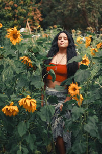 Beautiful woman with eyes closed standing amidst plants