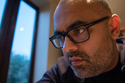 Close-up of man wearing eyeglasses at home