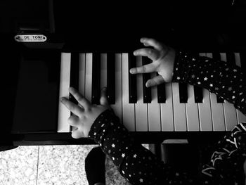 Close-up of hand playing piano