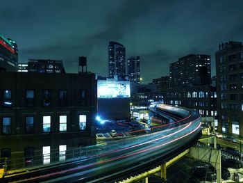 High angle view of illuminated street amidst buildings at night