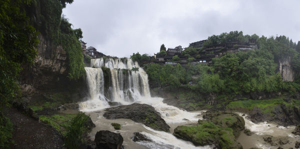 Scenic view of waterfall against sky