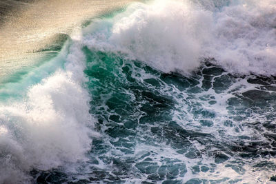 Waves splashing in sea against sky