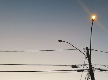 Low angle view of illuminated street light against clear sky