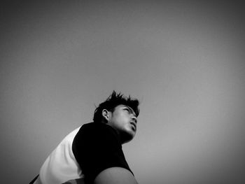 Portrait of young man looking away against white background