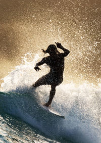 Silhouette man surfing in sea