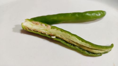 Close-up of green chili pepper against white background