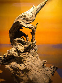 Close-up of statue against orange sky