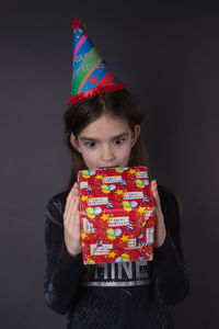 Portrait of girl standing against gray background