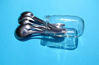 Close-up of spoon in glass jar on blue table