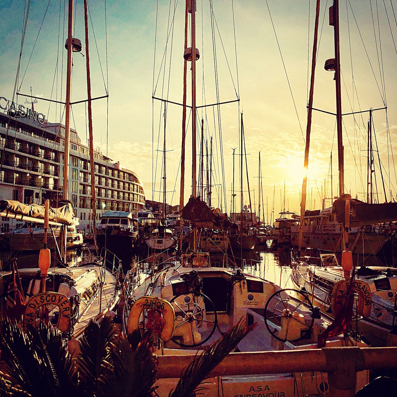 SAILBOATS MOORED AT HARBOR AGAINST SKY