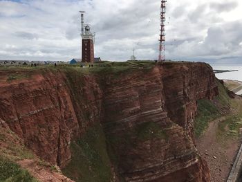 Lighthouse on cliff against sky