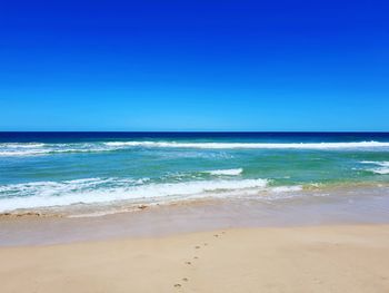 Scenic view of sea against clear blue sky