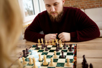 Couple playing chess at table