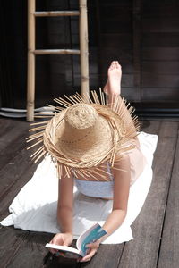 Rear view of woman with hat on table