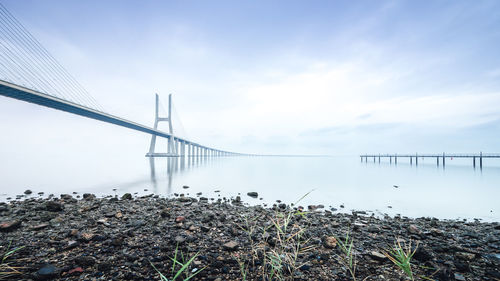 Suspension bridge over sea against sky