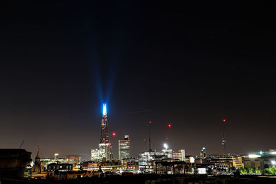 Illuminated buildings against sky at night