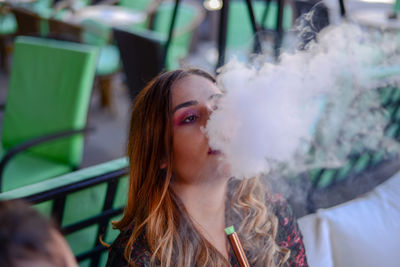 Close-up of young woman smoking outdoors