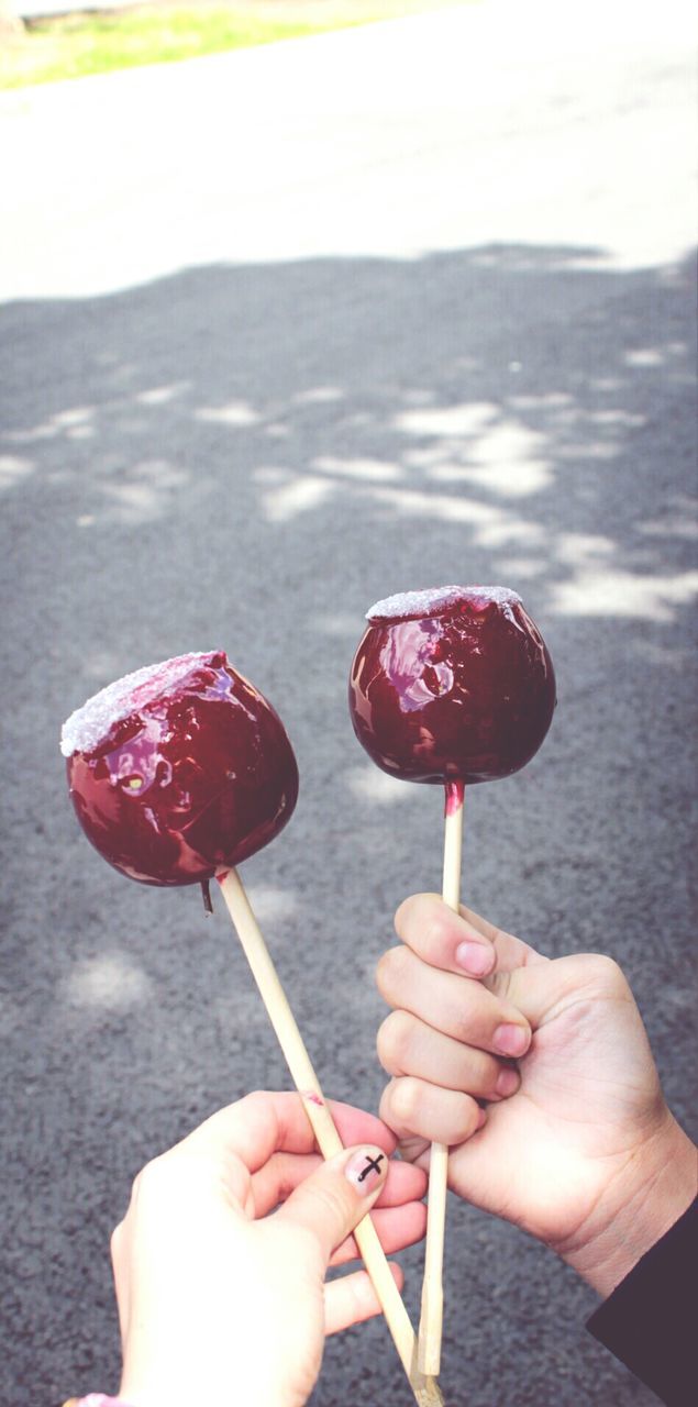 person, holding, food and drink, part of, food, cropped, freshness, human finger, sweet food, indulgence, frozen food, red, ice cream, unrecognizable person, close-up, focus on foreground, personal perspective