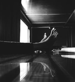 Low section of woman relaxing on floor at home