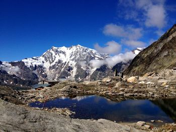 Scenic view of snowcapped mountains against blue sky