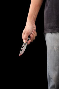 Close-up of hand holding hands against black background