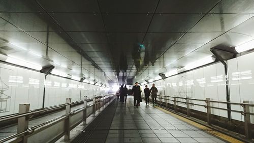 People walking in illuminated corridor