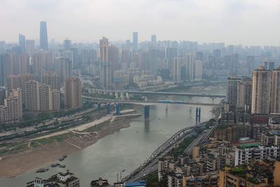 High angle view of city by river against sky