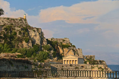 Built structure by sea against sky