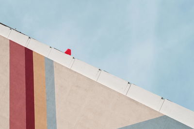 Low angle view of flag on building against sky