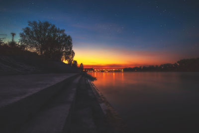 Scenic view of lake against sky at sunset