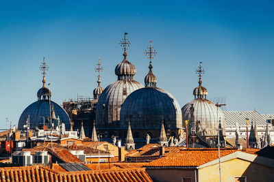 Panoramic view of buildings in city against clear blue sky