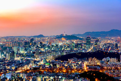 High angle view of city lit up at sunset