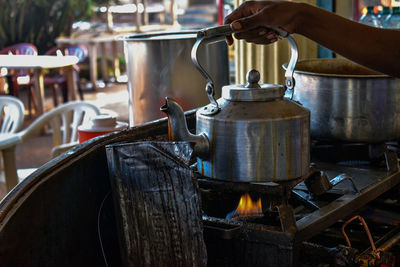 Cropped hand of person making tea at market stall