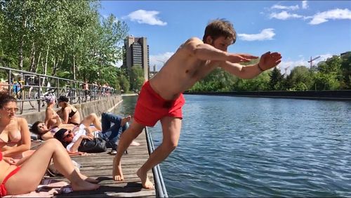 Rear view of shirtless boy in swimming pool against lake