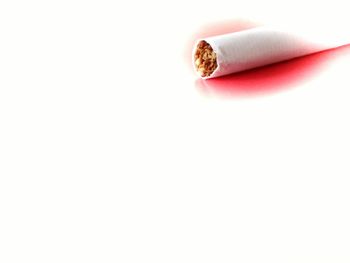 Close-up of cigarette over white background