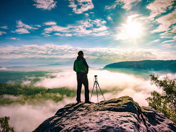 Rear view of man standing on land against sky