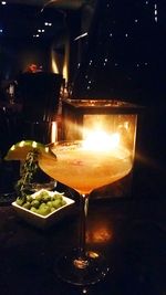 Illuminated tea light on table in restaurant at night