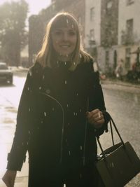 Portrait of a smiling young woman in city