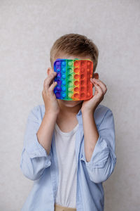 Full length portrait of boy standing against wall