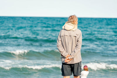 Man standing in sea against sky