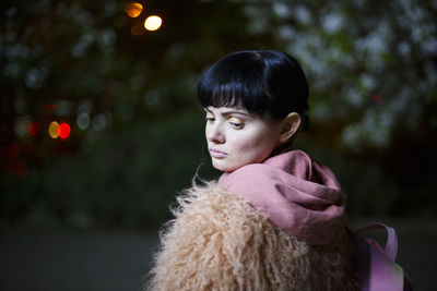 Portrait of young woman looking away outdoors