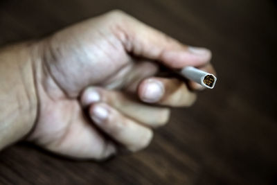 Close-up of hand holding cigarette