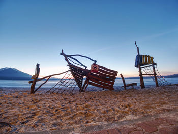 Wooden ship playground attraction for children in swimming bay. pirate bay at frozen water of lake.