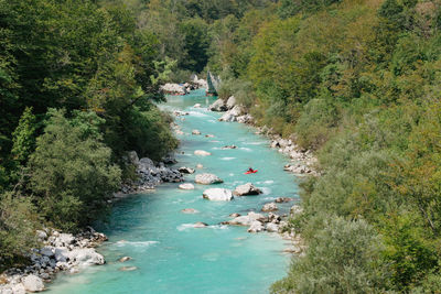 Man kayaking on the soca river with emerald color in slovenia