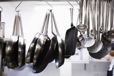 Utensils on metal rack in commercial kitchen